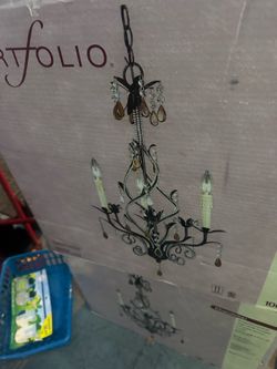 New in box Portfolio chandelier box features a transitional-style fixture with bronze-finished vine details and hanging crystals