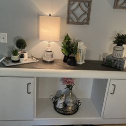 Entry table white with white shelf in the middle for baskets and two side door with shelves