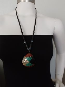 PUEBLO NECKLACE DECORATED WITH ONYX, RED CORAL, MOTHER OF PEARL AND TURQUOISE SET IN A CHIP INLAY FASHION.