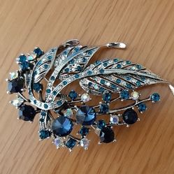 Brooch with blue, green and glass stones.