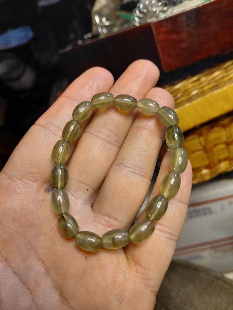 stretch bracelet made of polished, translucent, football-shaped glass or quartz beads. 