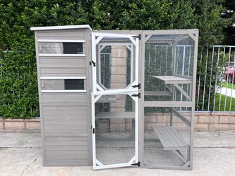 Large outdoor wooden cat enclosure with fixtures and an enclosed cat house.