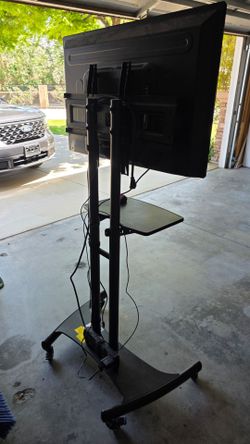 Rolling TV stand with shelf and TV
