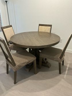 Round wooden dining table with chairs