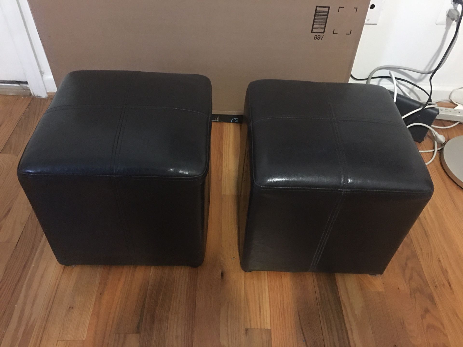 A Pair Of Faux Leather Ottomans