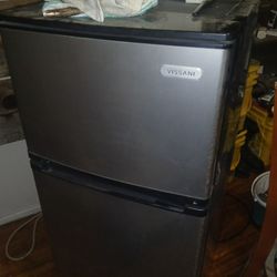 Mini refrigerator with freezer.