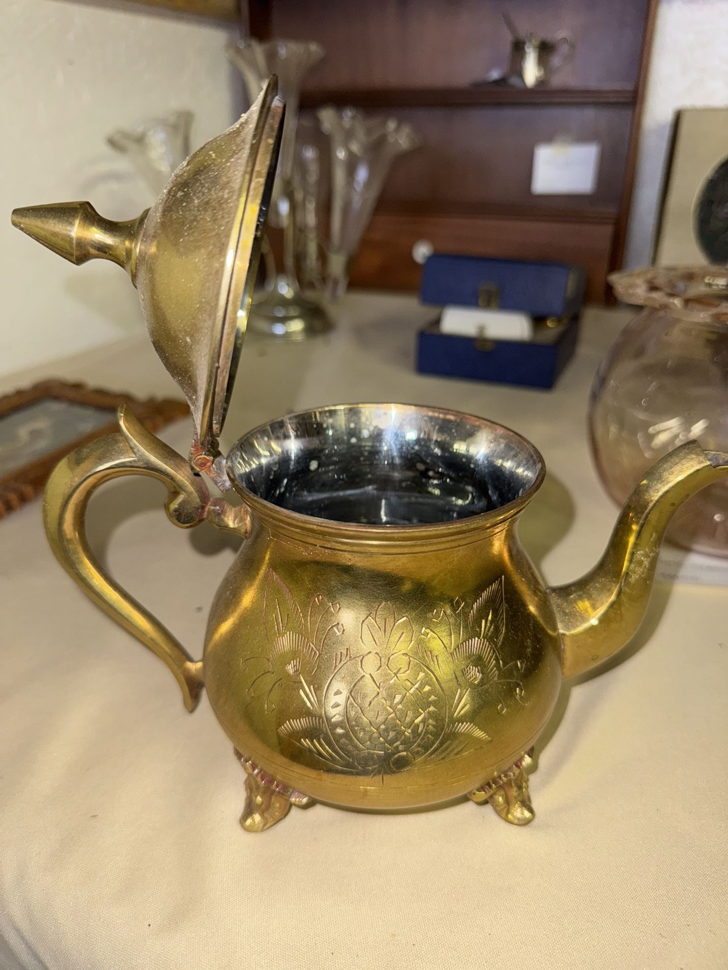 Vintage etched brass teapot with pineapple and floral motifs.