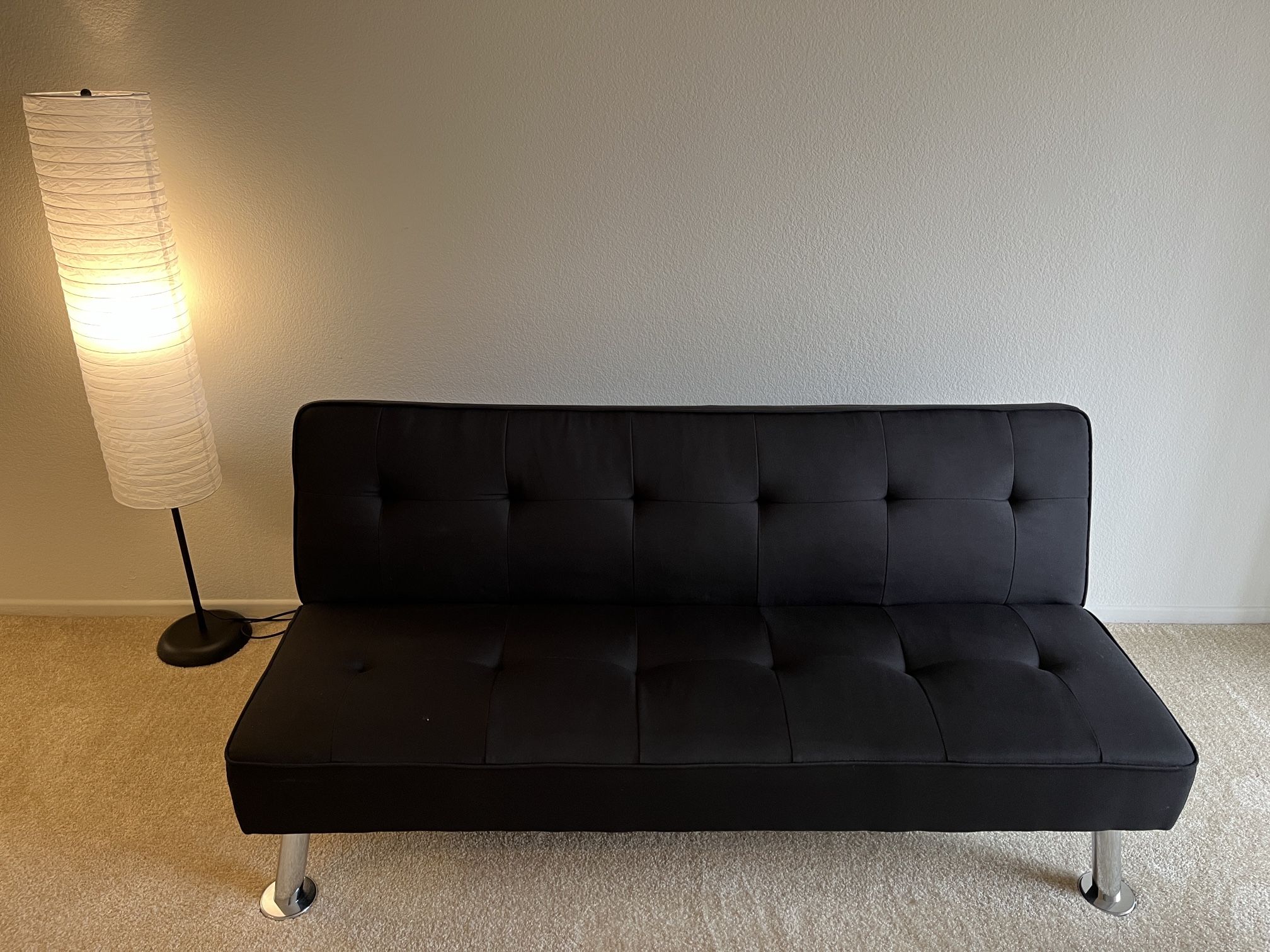 Black convertible sofa bed with built-in USB charging port.