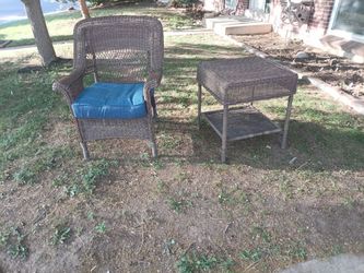 Patio wicker chair and matching side table for sale.