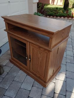 Classic oak color entertainment center. Open component 2 adjustable shelves. 2 fold out storage shelves behind door. Excellent condition. 34H 37W
