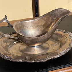 Vintage silver-plated gravy boat with an attached underplate.