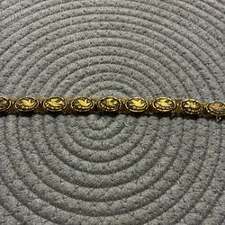 vintage damascene link bracelet featuring intricate gold and black designs of birds and flowers.