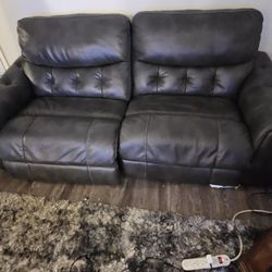 Dark Grey Recliner love seat Many different levels to recline, has charger for your phone on the side