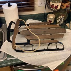 Wooden sled in great condition. Approximately 22” long and 12” wide has rope to steer or to hang as decoration. Metal base no rust never used outdoors