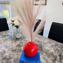 Red vase with artificial pampass and 2 books