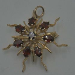 14kt yellow gold pin/pendant with garnet stones total weight 8.3 gr pre owned . 7 oval and 1 round garnet stones. 821296-1.   