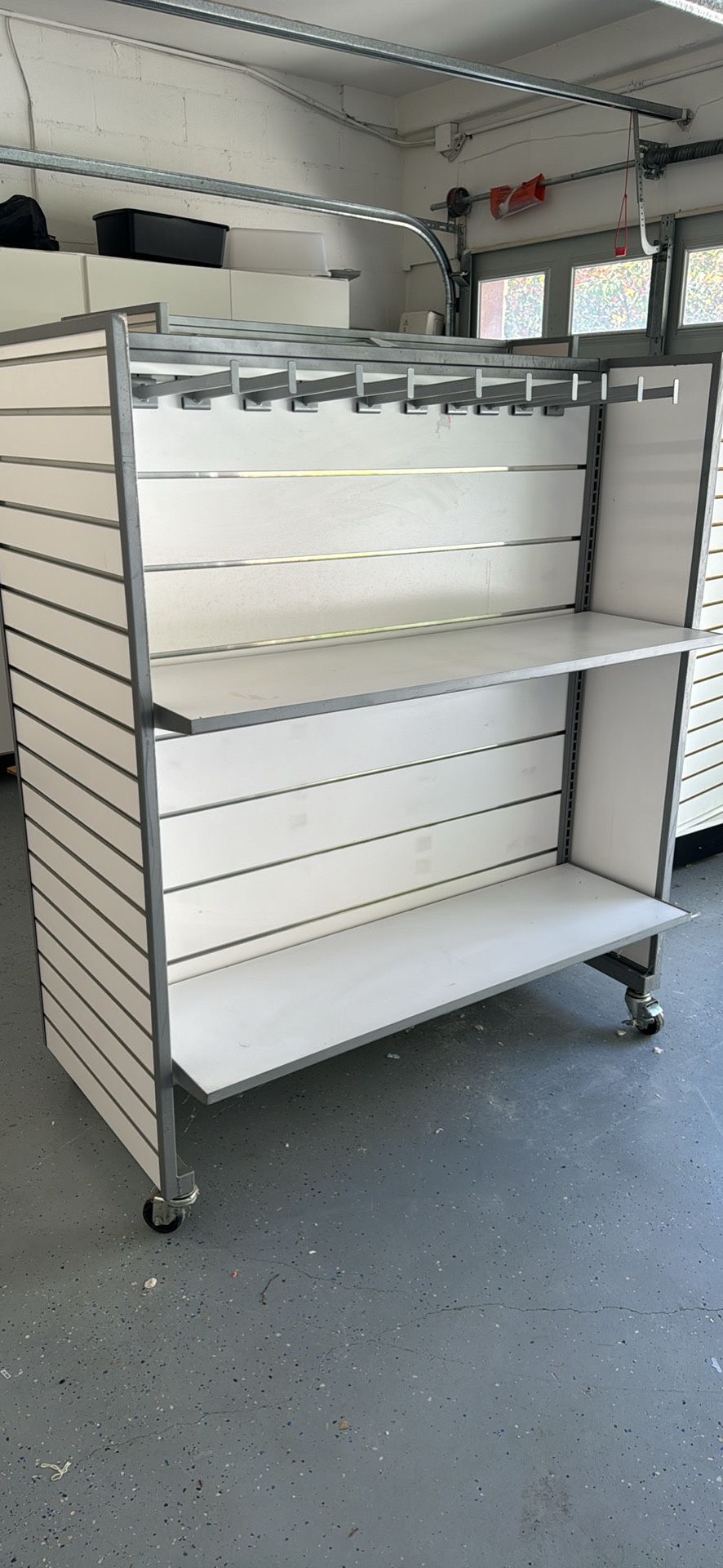Slatwall display on wheels with 4 shelves & metal hangers. Retail storage. 
