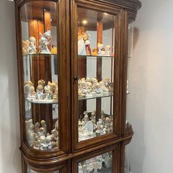 All wood lighted curio with glass shelves and mirror background