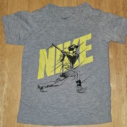 This Nike kids' t-shirt features a striking graphic design in gray and yellow. Perfect for active play and casual wear.