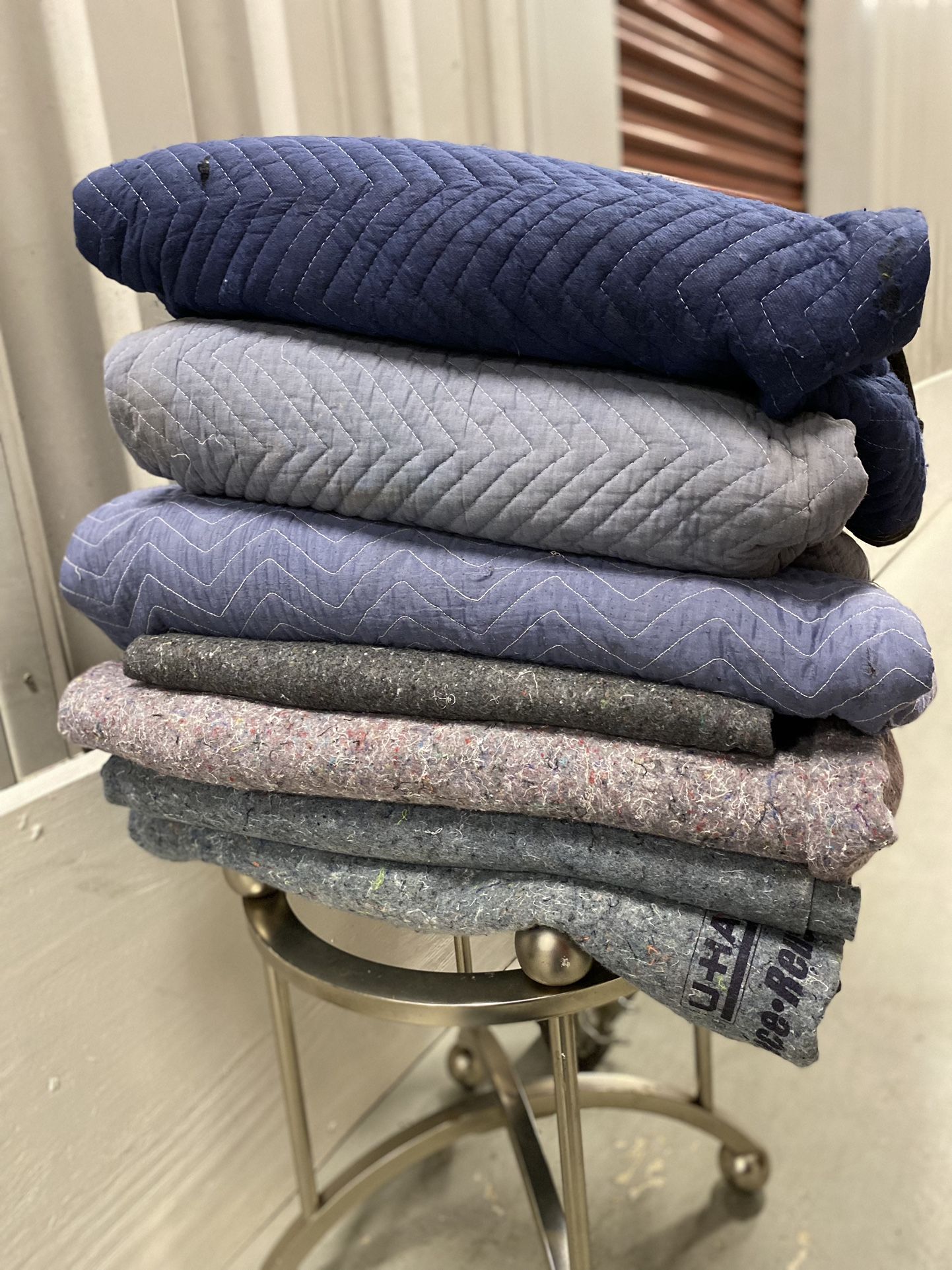 Bundle of 7 Moving Blankets Some The Heavy Quilted Style. Others just the sort of heavy blanket with the fibers showing. See photos. Pick up availab