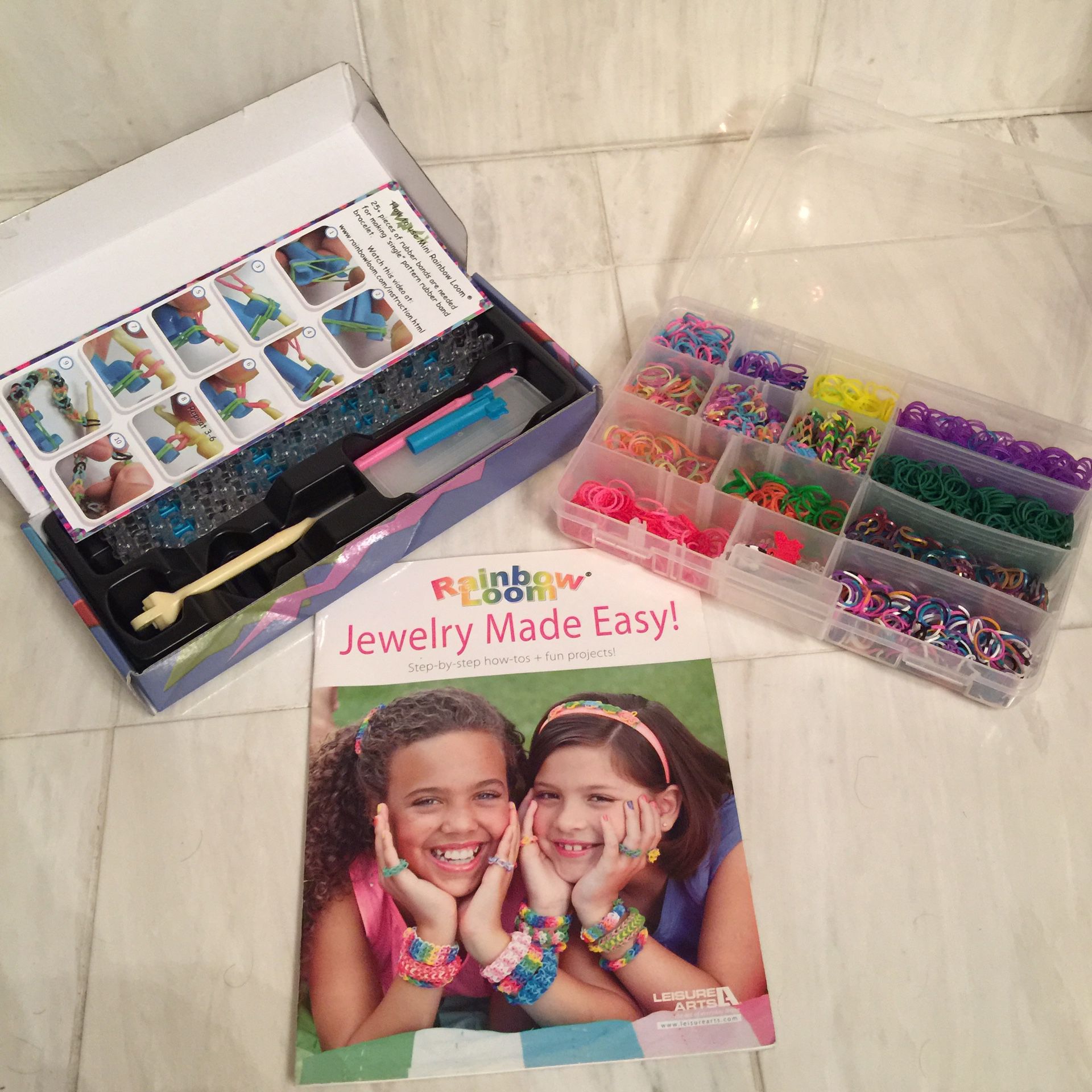 Rainbow loom plus caddy with lots of bands and a How To book