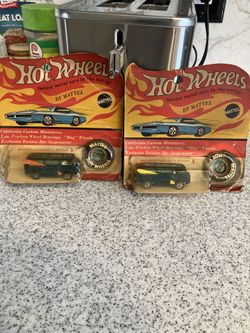 Two Hot Wheel Vans With Surfboards On The Side.