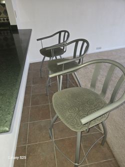 swivel stools feature upholstered seats and curved metal backrests.  24 Inch