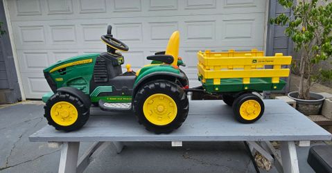 Kids John Deere Ground Force 12V Ride-On Tractor with Trailer, and it is manufactured by Peg Perego., Good condition, brand new charger, Normal wear