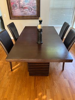 Large wooden indoor dining table with 4 chairs