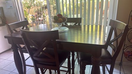 Brown table and 4 high chairs.