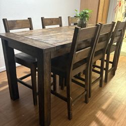 Rustic wooden dining table with 6 matching chairs. Solid wood construction. Great for family meals or game nights.