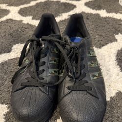 Black Adidas Superstar shoes camouflage-patterned stripes