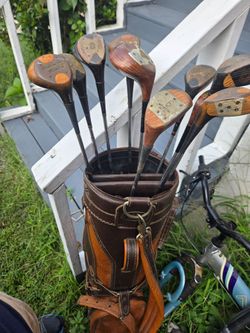 Golf clubs in a leather bag and golf bag cart