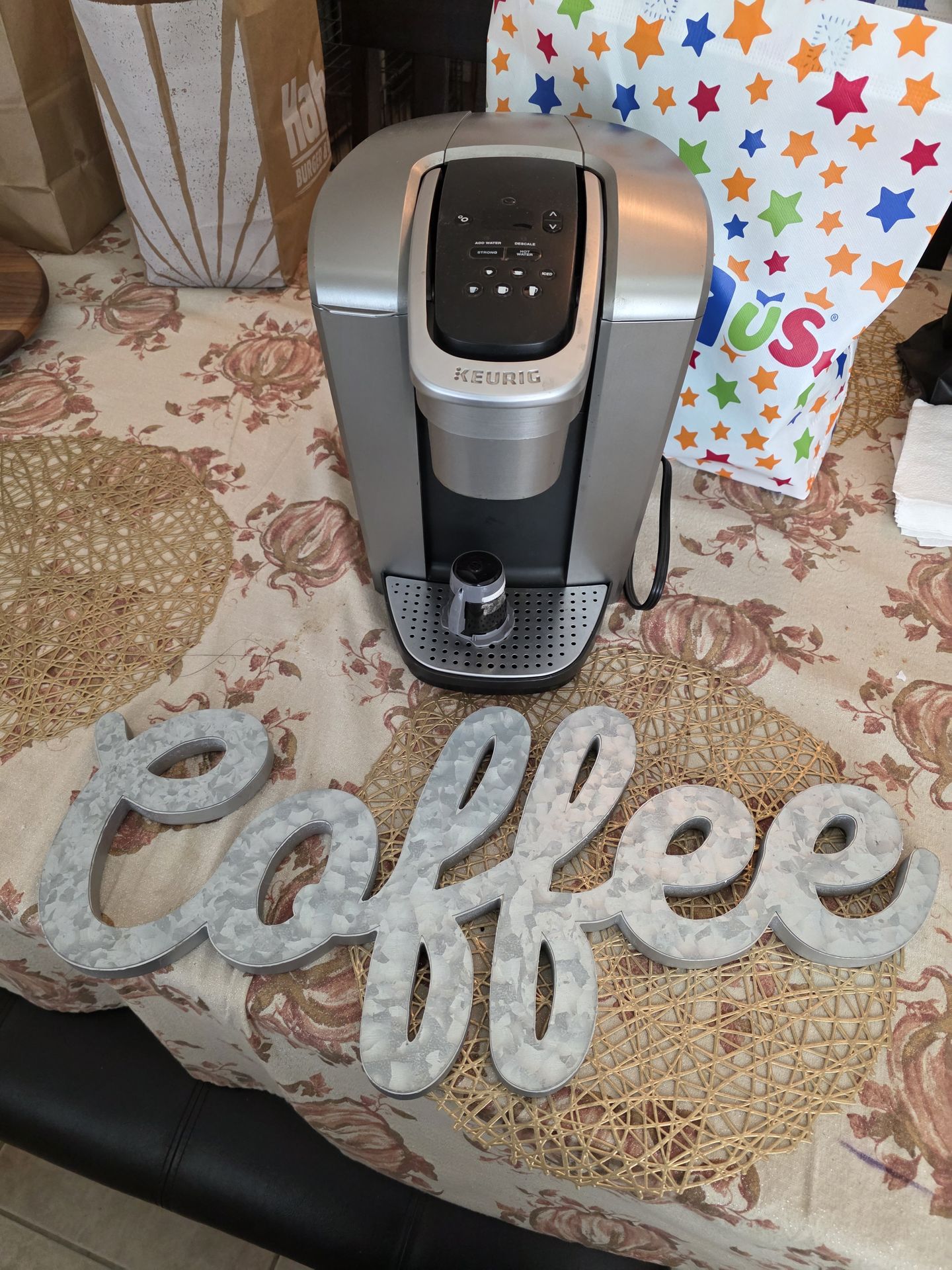 Keurig coffee maker with reusable pod and a coffee sign