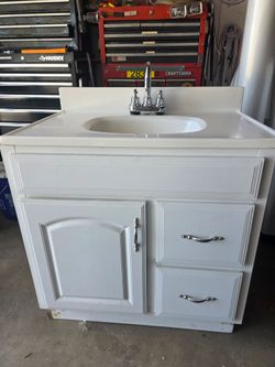 Bathroom cabinet used with counter top and faucet.