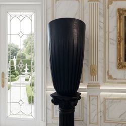classic Roman-style architectural column pedestal and a matching large, fluted/ribbed planter