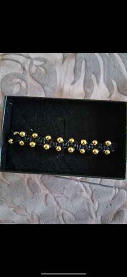 Pulsera de hilo hecha con bolitas de oro. Chapeado interesados en $60.