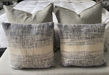 Set of two decorative toss pillows in gray and cream. Subtle woven stripe texture adds depth and a relaxed, modern look. Soft gray backing with contra