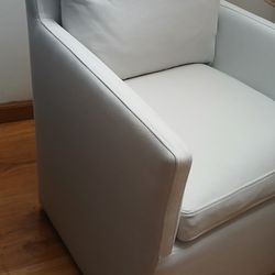 chair with wheels and upholstered in ivory high-performance fabric with feather cushions