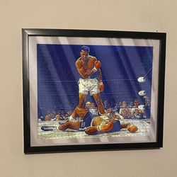 Art piece of Muhammad Ali knocking out sonny Liston in black frame