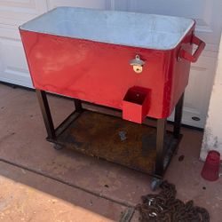 Cooler on a cart with bottle, cap opener, and drain hole
