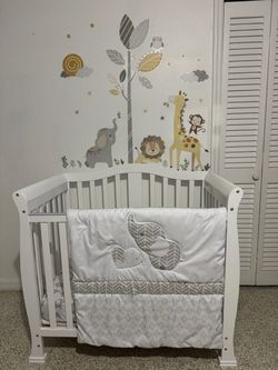 4-in-1 Convertible Mini Baby Crib in White with matress and bedding set included.