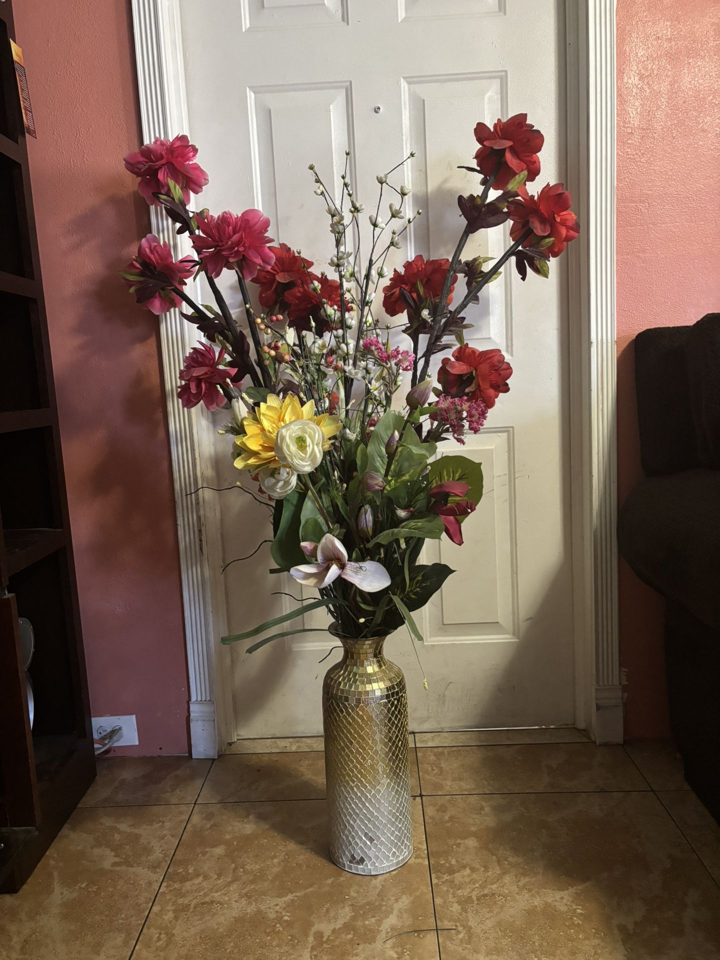 tall, decorative vase filled with an arrangement of artificial flowers