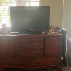 A Large Hutch, An Eight drawer dresser, a nightstand, an accent chair, a tea cart, and a 42 inch flatscreen TV.