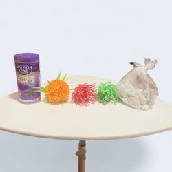 This bundle of aquarium supplies includes a container of fish food, three artificial plants, and a bag of assorted fish tank decorations. 