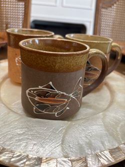 Three vintage stoneware pottery mugs with handpainted fish.