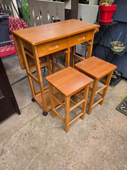Hideaway table with two stools. 14x 28 with leaf down and 28x 28 with the leaf up. Comes with two stools that hang under it. It is on wheels and has t