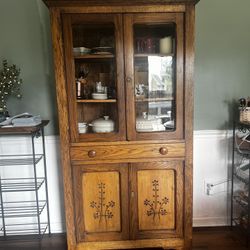 Antique oak cupboard with glass doors and flower carvings