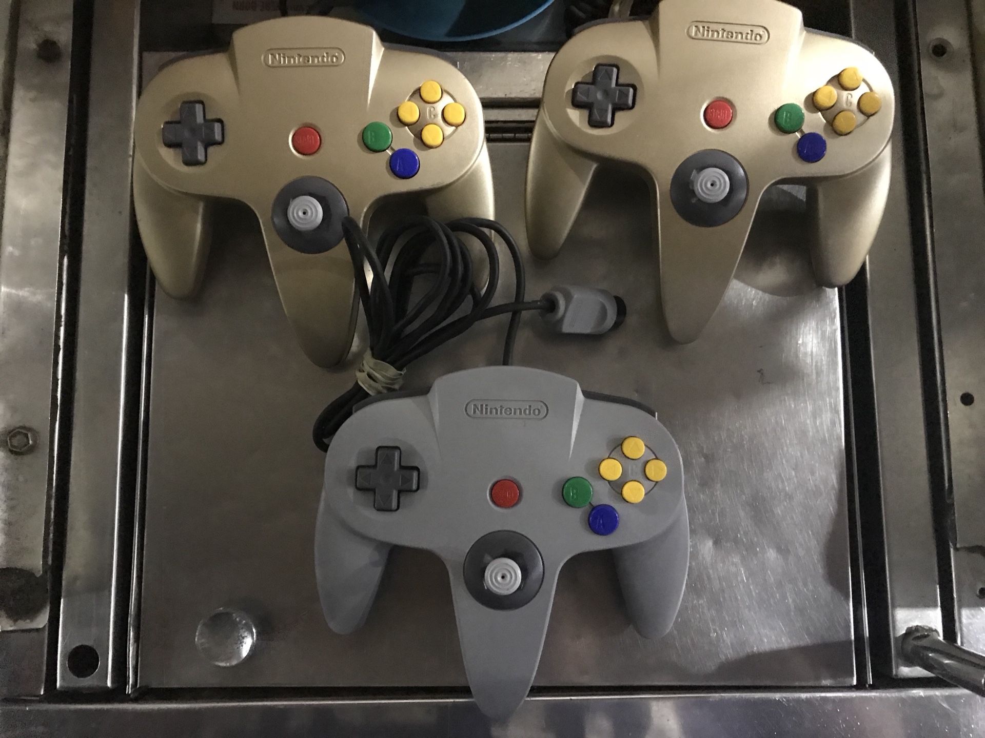 (3) Nintendo 64 controllers. 2 Gold 1 Gray. Excellent Condition.