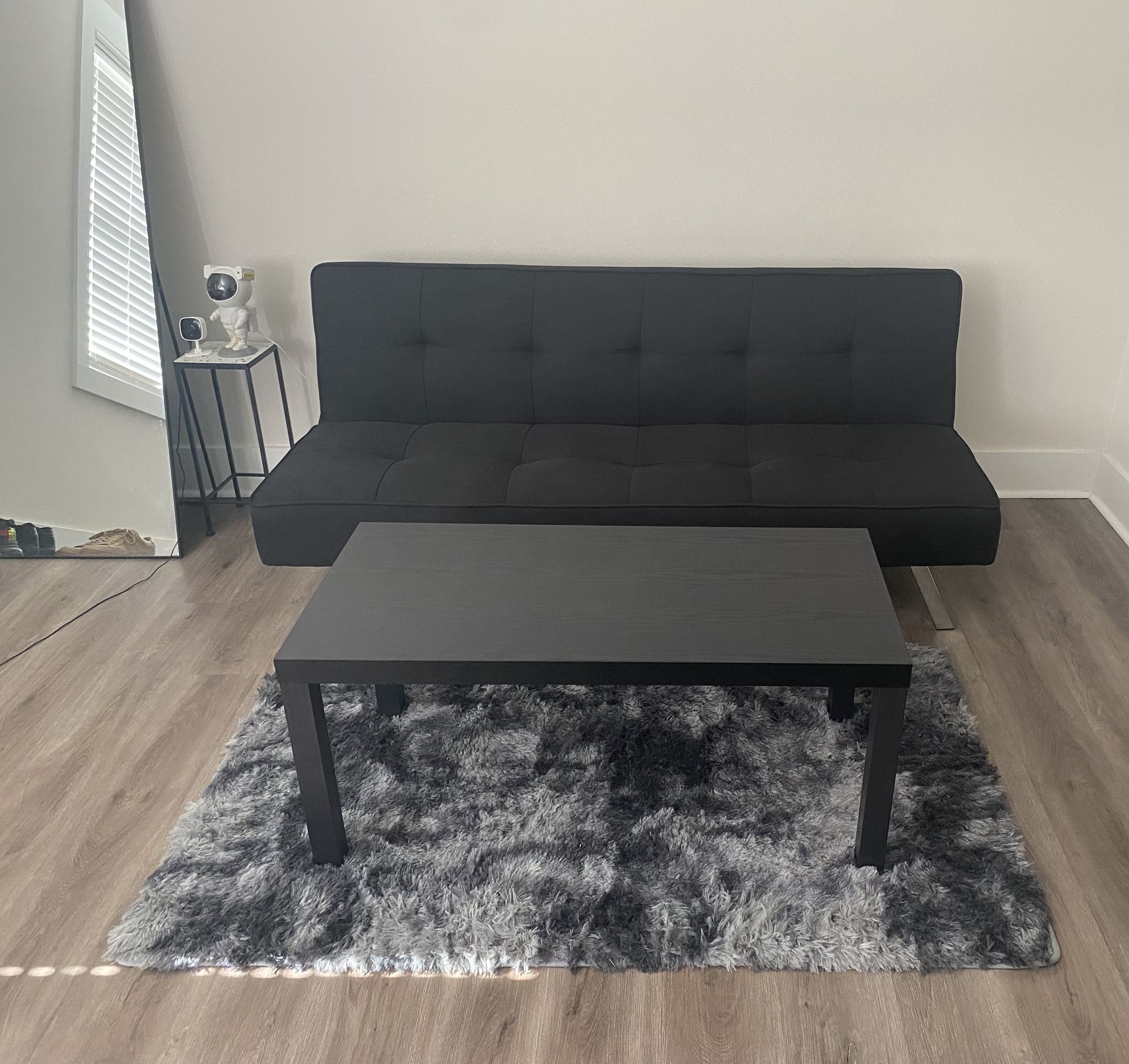 Black Futon With Coffee Table And Charcoal Rug